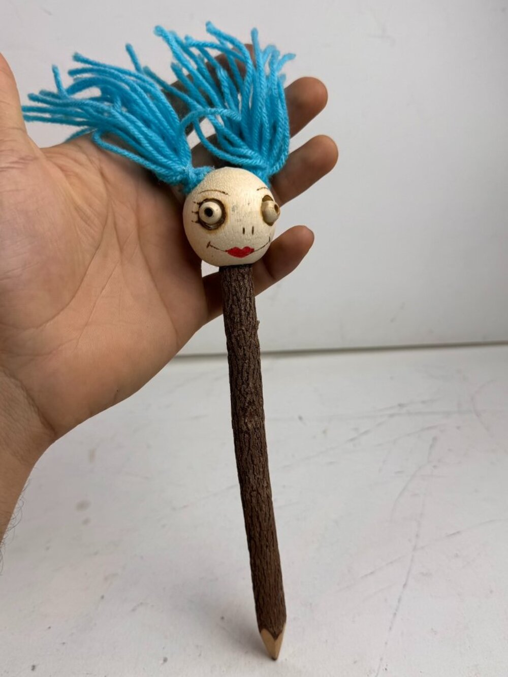 Vintage Folk Art Hand-Carved Wood Twig Pencil Troll Doll Head Blue Yarn Hair 8"